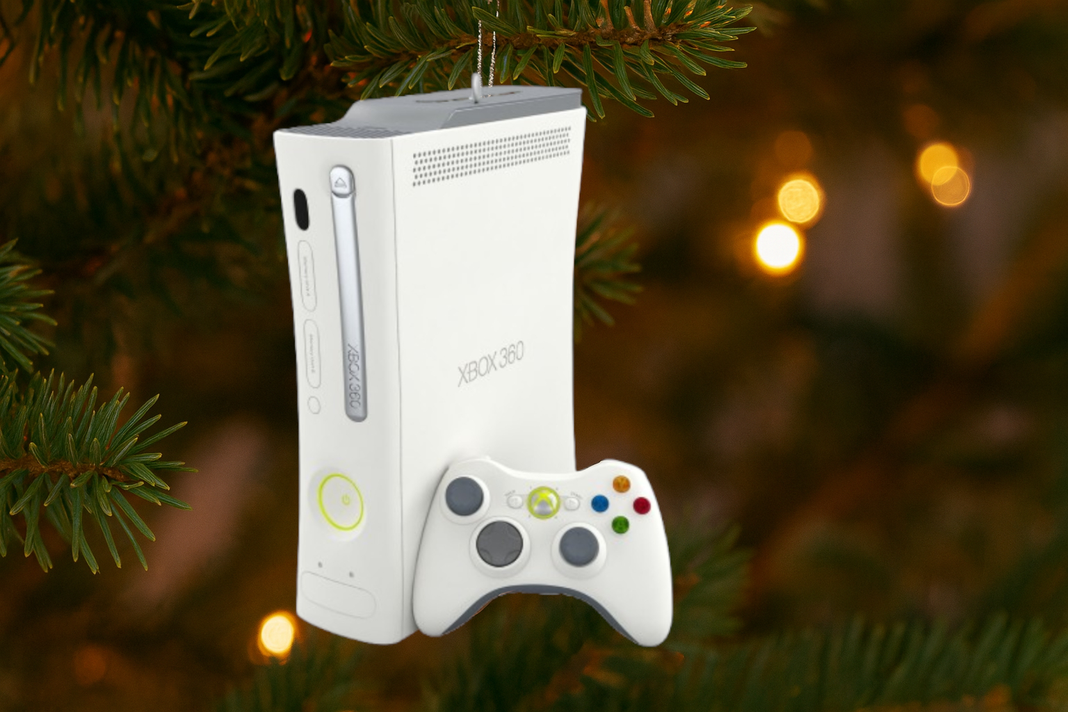 A white gaming console and controller hanging from a christmas tree